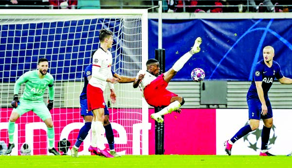 Leipzig's Nordi Mukiele (center) jumps for the ball in front of Tottenham's goalkeeper Hugo Lloris (left) during the Champions League round of 16, 2nd leg soccer match between RB Leipzig and Tottenham Hotspur at Leipzig in Germany on Tuesday.