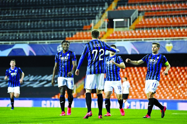 Atalanta's Josip Ilicic celebrates with teammates after scoring his side's fourth goal during the Champions League round of 16, second leg soccer match between Valencia and Atalanta, at Valencia in Spain, Tuesday. The match is being in an empty stadium