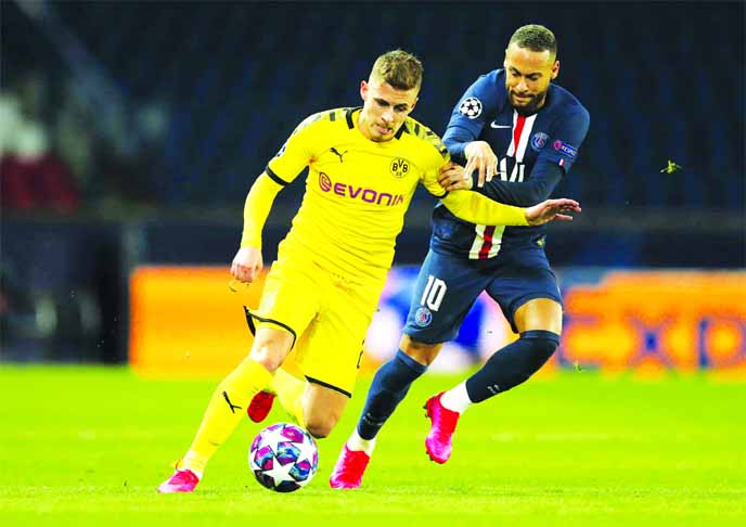 Paris Saint Germain's Neymar (right) vies for the ball with Borussia Dortmund's Thorgan Hazard during the Champions League round of 16 second leg soccer match between PSG and Borussia Dortmund in Paris on Wednesday. The match is being played in an empt