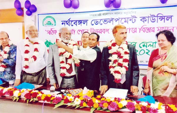 Founding President of 'Bangladesh Sahojogi Muktijoddha Sangsad' Lutfar Rahman greeting President of North Bengal Development Council (NBDC) Dr Mojibur Rahman presenting bouquet at the orientation ceremony and general meeting of NBDC held on Saturday at