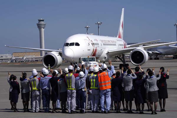 Ground crews of Japanese airlines wave to the special "Tokyo 2020 Go" aircraft that will transport the Olympic Flame to Japan from Greece, on its departure at Haneda International Airport in Tokyo on Wednesday.