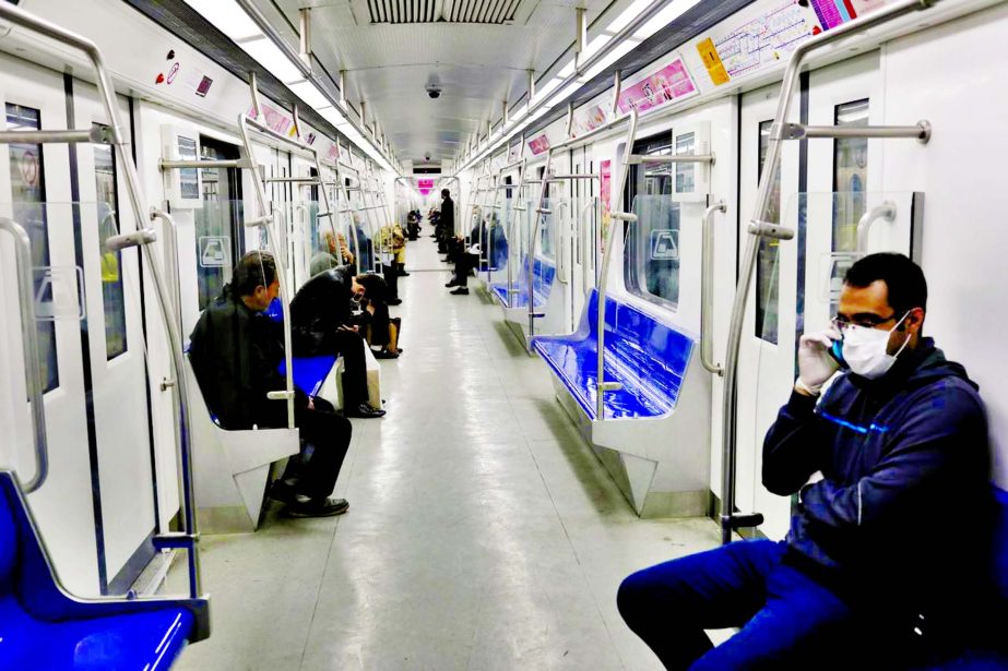 People wear protective face masks, following the outbreak of coronavirus, as they sit in a metro in Tehran, Iran.