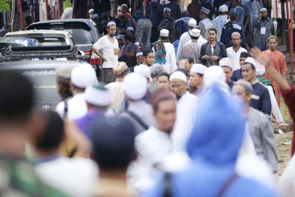 Pilgrims make their way through the crowd on a field where a mass congregation is supposed to be held in Gowa, South Sulawesi, Indonesia on Thursday.