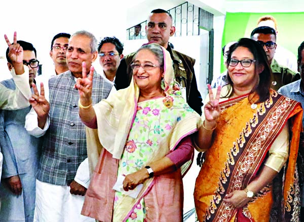 Prime Minister and Awami League President Sheikh Hasina accompanied by party candidate of Dhaka-10 by-election Shafiul Islam Mahiuddin showing victory 'V' sign after casting vote at Dhaka City College center on Saturday. BSS photo