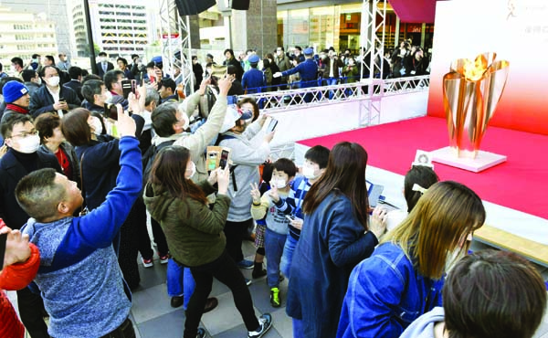 People gather to take a look at Olympic flame on display in Sendai, Miyagi prefecture, north of Tokyo on Saturday. The Olympic flame from Greece arrived in Japan Friday, and the flame will be on public display in the some areas affected by the 2011 earthq