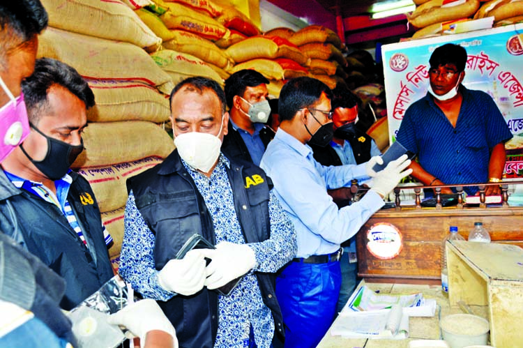 A Rapid Action Battalion (RAB) mobile court led by Executive Magistrate Sarwoer Alam conducts a drive at a rice godown in the capital's Babubazar area on Monday amid sudden hike in rice prices.