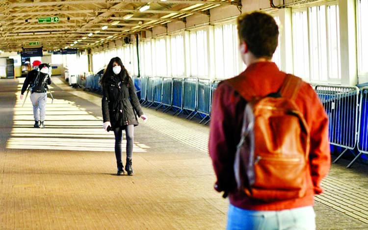 A woman wears a mask at Clapham Junction during rush hour as the spread of the coronavirus disease continues in London on Monday.