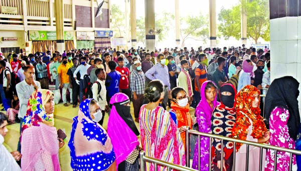 Railway passengers overcrowd the city's Kamalapur Railway Station on Tuesday for going to their village homes to protect themselves from fatal coronavirus.