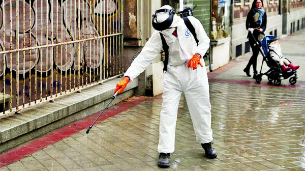 A municipal worker in protective gear disinfects a street during the coronavirus disease outbreak in Madrid, Spain.