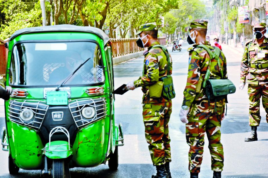Army personnel check driving documents from a CNG driver at Shahbagh intersection during their patrolling in Dhaka streets on Friday.