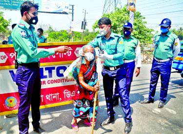 Police personnel distribute facemask to a destitute woman at Demra in Dhaka on Saturday as part of their ongoing social distancing campaign amid coronavirus outbreak.