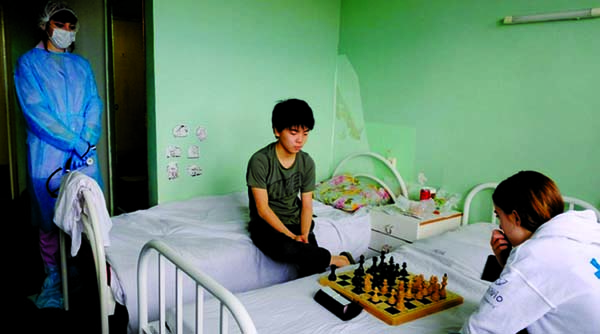 Chess players from France look at the board during a game at a hospital in Murmansk, Russia on Saturday. The tournament they were taking part was quickly derailed when an Irish player was diagnosed with the coronavirus, forcing other participants into qua