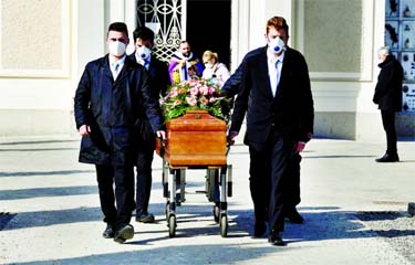 Pallbearers wearing protective masks carry the coffin of a woman who died from coronavirus disease at her funeral, as Italy struggles to contain the spread of disease.