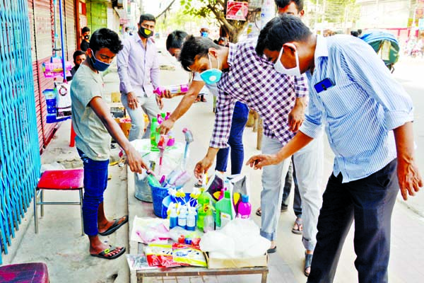 Commoners seen to sell hand gloves, masks and germicide on footpath. The snap was taken from the city's Malibagh Chowdhury Para on Monday.