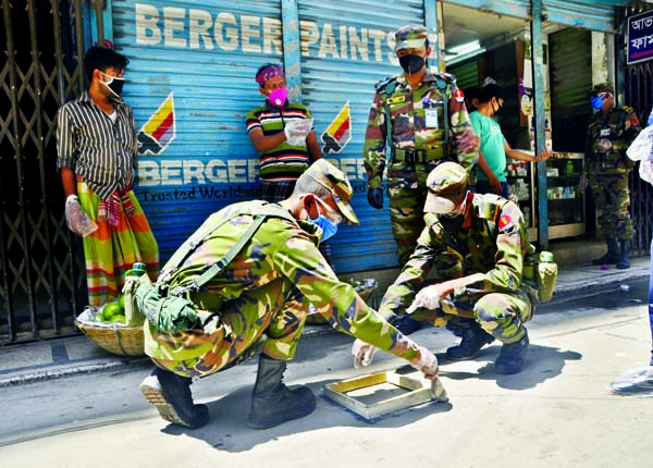 Army personnel warning commoners painting 'round circle' in front of shops in different markets in the city with a view to protecting from coronavirus. The snap was taken from Shantinagar Bazar on Wednesday. NN photo