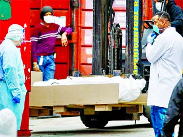 A body wrapped in plastic is prepared to be loaded onto a refrigerated container truck used as a temporary morgue by medical workers due to COVID-19 concerns at Brooklyn Hospital Center in the Brooklyn borough of New York. Internet photo