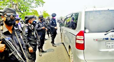 RAB personnel stop a microbus and query the passengers at Shanir Akhra in Dhaka on Thursday as the government orders citizens to stay at home to enforce home quarantine and social distancing during countrywide shutdown amid spread of coronavirus.