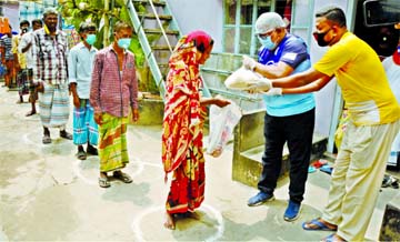 Councilor of 5 No Ward of DSCC Chittaranjan Das distributing relief materials among the poor on the office premises on Friday.