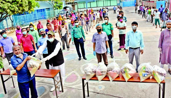 Chairman of the Governing Body of the city's Willes Little Flower School and College Arifur Rahman Titu distributing foods among the destitute on the premises of the institution on Saturday. Foods were bought from the joint aid of the teachers and gover