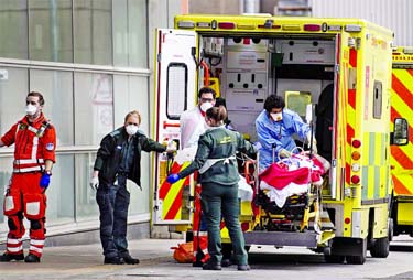 Paramedics wearing personal protective equipment transport a patient into The Royal London Hospital in East London recently.