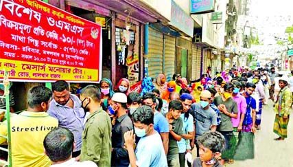 The people of low-income groups are seen in a long queue to purchase rice of OMS. This picture was taken from Lalkhan Bazar area in Chattogram on Sunday.
