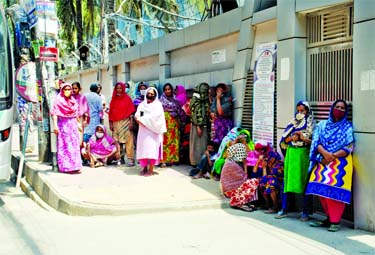 Destitute women wait for relief in front of a house at Malibagh in the city on Monday as they lost income due to the nationwide shutdown enforced to contain spread of coronavirus.