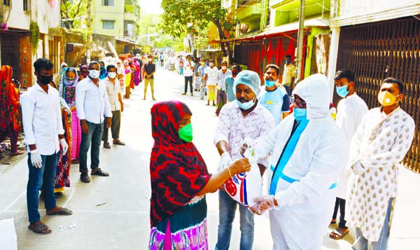 Councilor of 5 No Ward of DSCC Chittaranjan Das distributing relief materials among the people of low-income on the premises of the councilor's office on Tuesday.