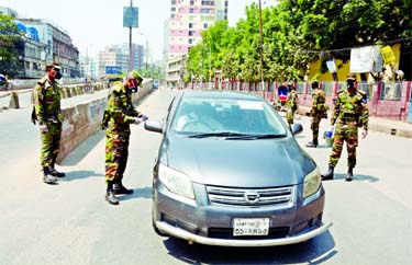 Army personnel intercept a private car on the face of Babu Bazar Bridge on Tuesday to prevent people enter or leave in Dhaka to contain spread of COVID-19.