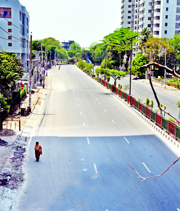 A poor woman walks an empty street in Dhaka for relief on Friday amid lockdown in the city due to coronavirus.