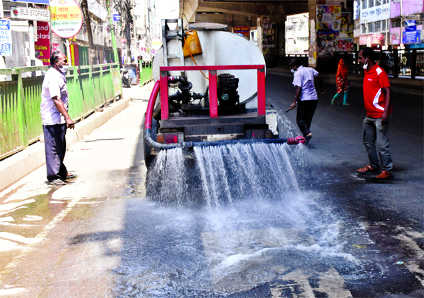Workers of Dhaka South City Corporation spraying germicide on the streets to prevent spread of coronavirus. The snap was taken from Maghbazar area on Saturday.