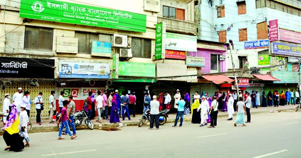 Account holders are seen in a long queue to withdraw money from their accounts by maintaining social distance during the lockdown over coronavirus. This picture was taken from in front of the Islami Bank Bangladesh, Rampura branch on Sunday.