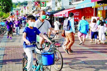 People wearing face masks are seen at Cheung Chau island during Easter weekend, amid the novel coronavirus disease outbreak in Hong Kong on Sunday.