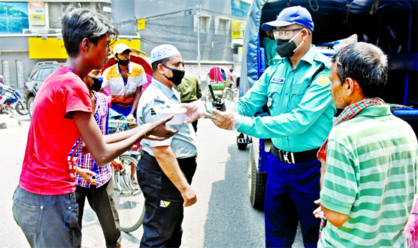 On behalf of DMP Commissioner, Wari thana police distributing food items among the destitute. The snap was taken from the city's Hatkhola Road on Thursday.