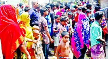 Desperate for food: Many men, women and children wait for relief on the road near Titipara slum in the city on Thursday violating the government's social distancing order issued amid outbreak of coronavirus.