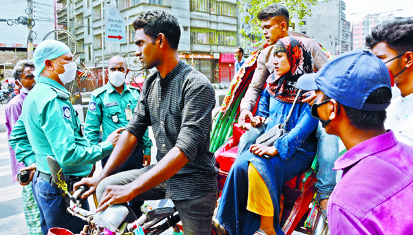 Law-enforcers intercepted passengers of a rickshaw for not wearing masks and hand gloves. The snap was taken from the city's Dayaganj intersection on Friday.