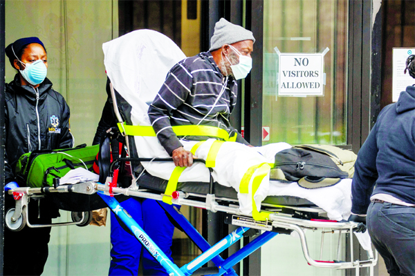 Emergency Medical Technicians (EMTs) wearing personal protective equipment wheel a man out of a nursing home into an ambulance during an ongoing outbreak of the coronavirus in the Brooklyn Borough of New York on Friday.