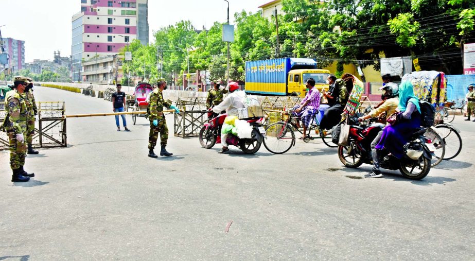 Army personnel stand guard at a checkpoint set up at Babubazar Bridge in Dhaka on Friday to prevent entry or departure of individual or vehicle to and from the city amid outbreak of the coronavirus.