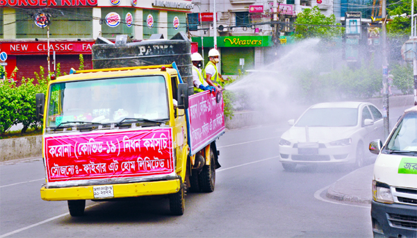 Different government and non-government agencies spraying water mixed with germicide on the street in the city's Gulshan area on Saturday.