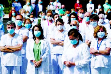 Staff from La Paz hospital applaud after a minute of silence to remember Joaquin Diaz, the hospital's chief of surgery who died of COVID-19, amid the coronavirus outbreak in Madrid, Spain, on Monday.