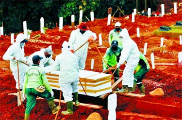 Municipality workers bury a coffin in a grave at a cemetery complex provided by the government for coronavirus disease victims in Jakarta on Wednesday.