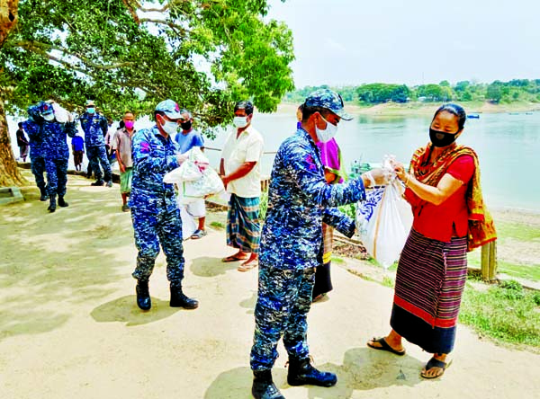 Members of Bangladeh Navy distributing food items among the poor in the remote area in Kaptai on Thursday to fight COVID-19 crisis. ISPR photo