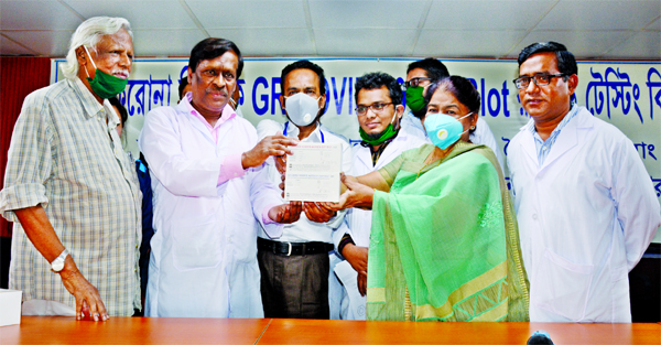 Founder President of the city's Ganoswasthya Kendra Dr. Zafrullah Chowdhury handing over its COVID-19 test kits to the representatives of Markin CDC and BSMMU for government approval at its conference room on Saturday.