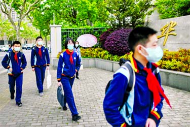 Students wearing face masks arrive at the Huayu Middle School in Shanghai on Monday for the first time since schools were closed down in January as part of efforts to stop the spread of the coronavirus.