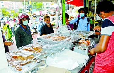 A vendor sells Iftar items from a shop in the city's Bailey Road on Tuesday following health guidelines and social distancing protocol.