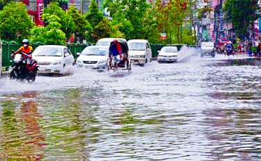 Streets, lanes and bylanes get submerge after a heavy rain in Dhaka on Tuesday due to poor drainage system. This picture of Nayapaltan intersection shows road pavement remains under ankle-deep water due to the monsoon shower.
