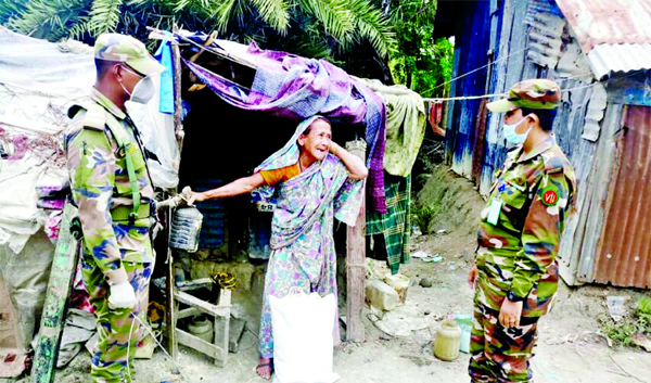 Members of Bangladesh Army distributing relief materials among the poor going to their houses in Barishal on Thursday to ensure home quarantine with a view to preventing coronavirus.