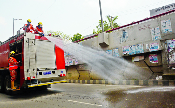 Members of Bangladesh Navy spraying germicide mixed water in the city streets to contain coronavirus spread. The snap was taken from Sat Rasta Intersection in the city's Tejgaon on Thursday.