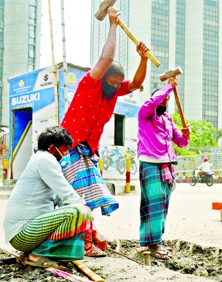 No End of Their Miseries: Workers hammering a wedge to break concrete on a city road on Thursday on the eve of the Historic May Day and ongoing nationwide coronavirus lockdown.