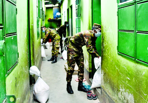 86 Independent Signal Brigade of Bangladesh Army distributing relief materials among the distressed people on Tuesday in the city's Bhasantek and Benarashi Palli to tackle coronavirus situation.