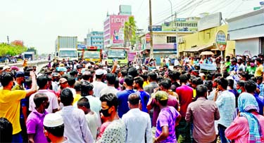 Transport workers block the Gabtoli-Savar Highway at Kalyanpur in Dhaka on Tuesday demanding cash support from their welfare fund and government's food assistance during the ongoing public holidays.
